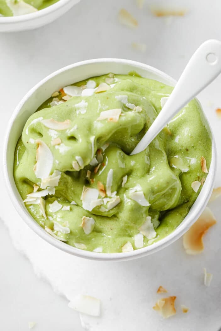 matcha nice cream in a white bowl with a spoon in it