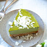 slice of vegan matcha cheesecake with coconut flakes spinkled on top