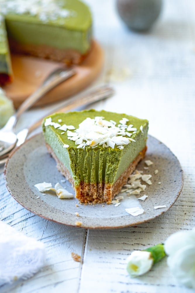 slice of matcha cheesecake with a piece removed