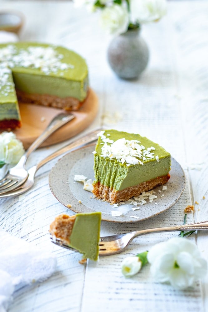 slice of matcha cheesecake with a piece removed