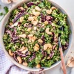 kale and quinoa salad in a large white bowl with a fork in it