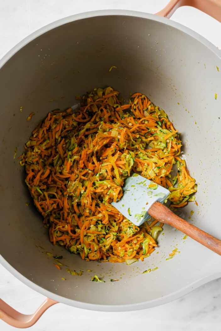 image of grated carrot and zucchini cooking in a saucepan