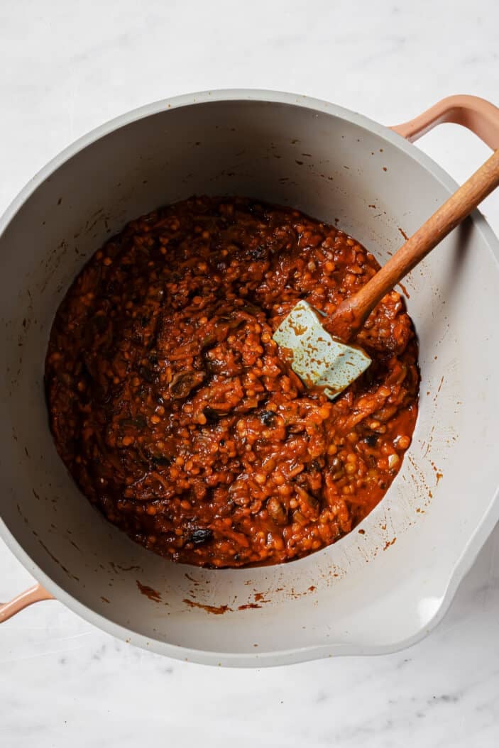 adding the tomato sauce to the vegetable mixture and stirring to combine