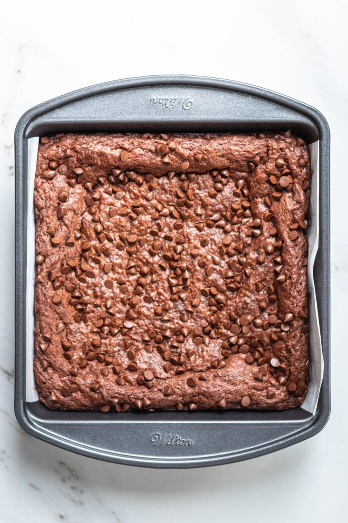 Baked brownies in a squire baking dish ready to be cut.