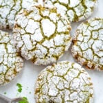 close up of matcha cookies with a bite of the lower right side and a spoon with matcha powder