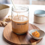 gingery miso sauce in a jar with a spoon in it.