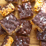 close up image of chocolate peanut butter rice crispy treats sprinkled with flaky sea salt