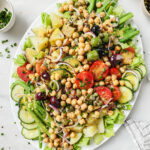 chickpea salad nicoise on a white serving dish on a white backdrop