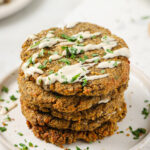 vegan lentil burger patties piled on top of each other and sprinkled with cilantro