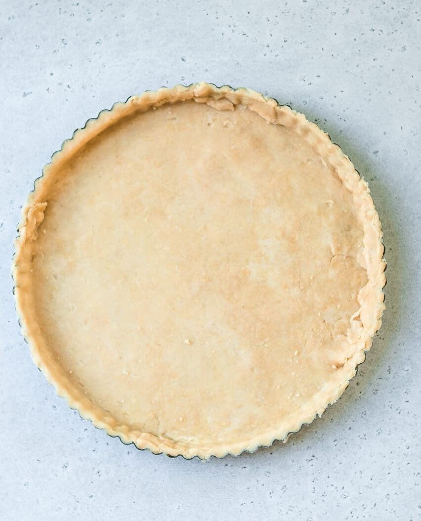 dough that's been rolled out and transferred to a tart pan, ready to be baked