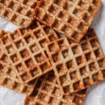 almond flour waffles piled together on a light backdrop. The waffles are showcased plain with no toppings.