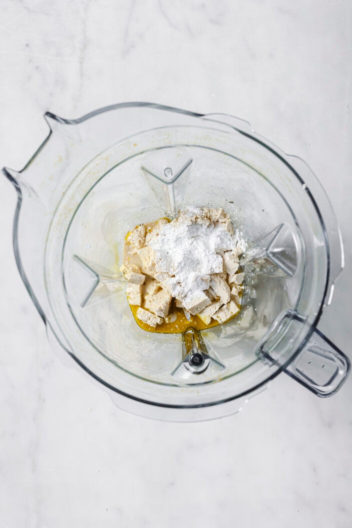 Add the tofu, spices and oat milk to a blender.