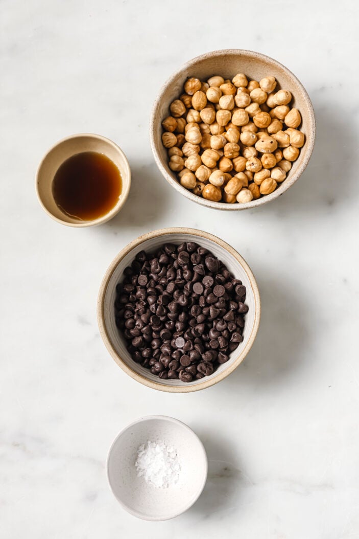 maple syrup, hazelnuts, chocolate chips and coconut oil all in individual bowls
